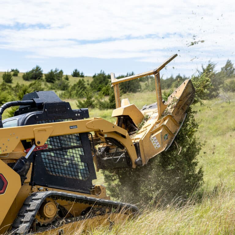 skid steer with disc mulcher cutting down a tree