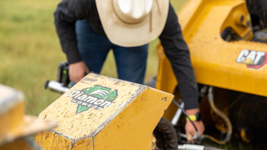 man greasing skid steer