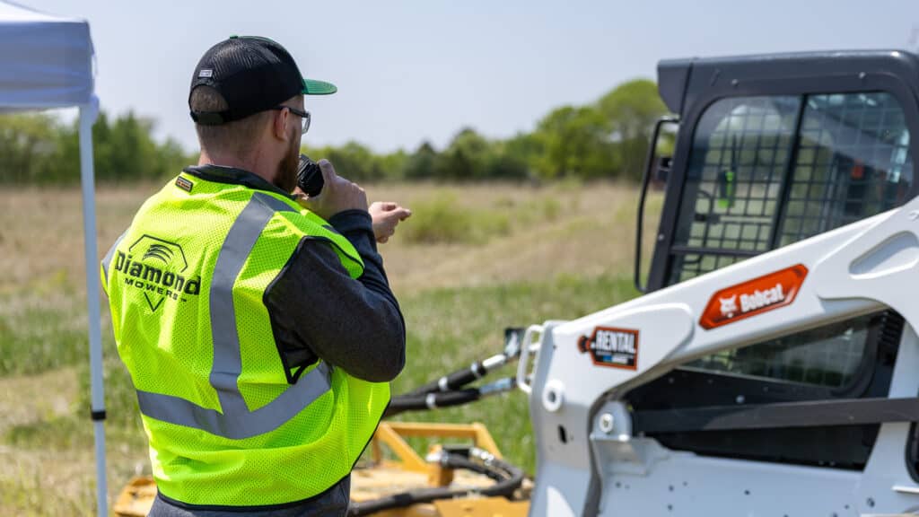 man talking to person using skid steer