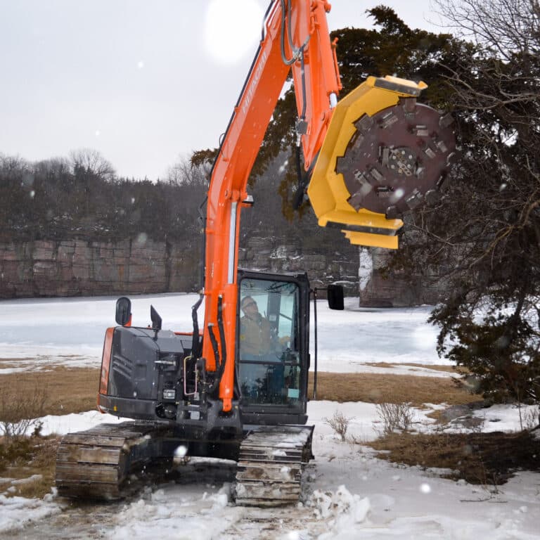 excavator with disc mulcher in snowy field