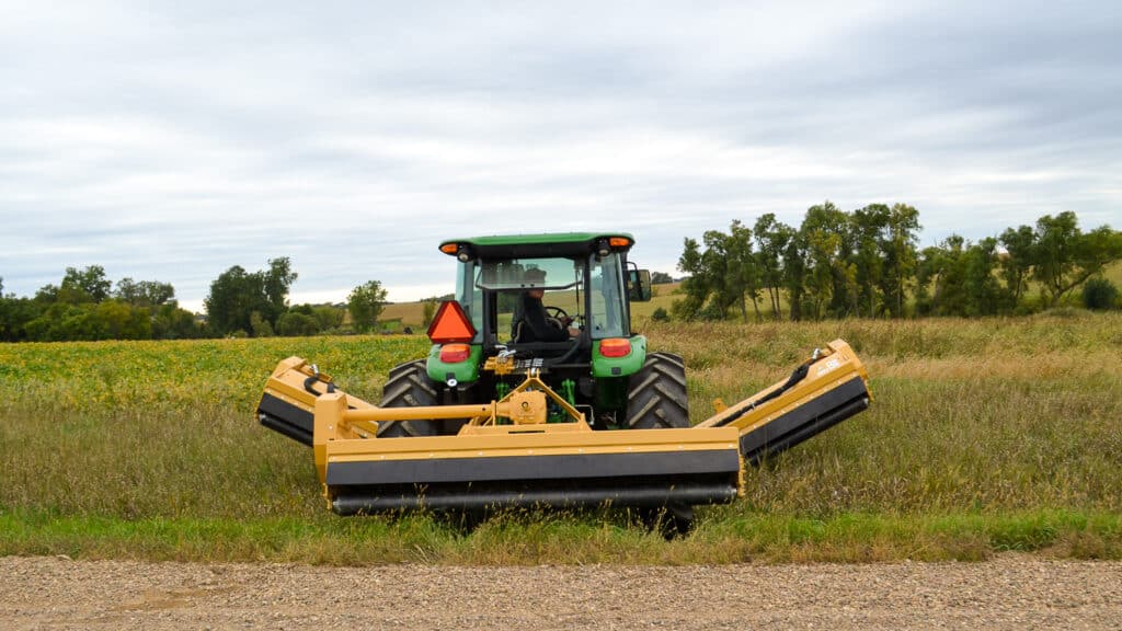 tractor with traditional triple flail on the back in a ditch