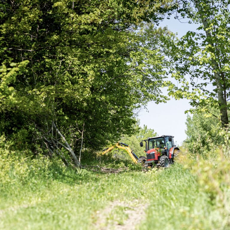 tractor with boom attachment in field approach