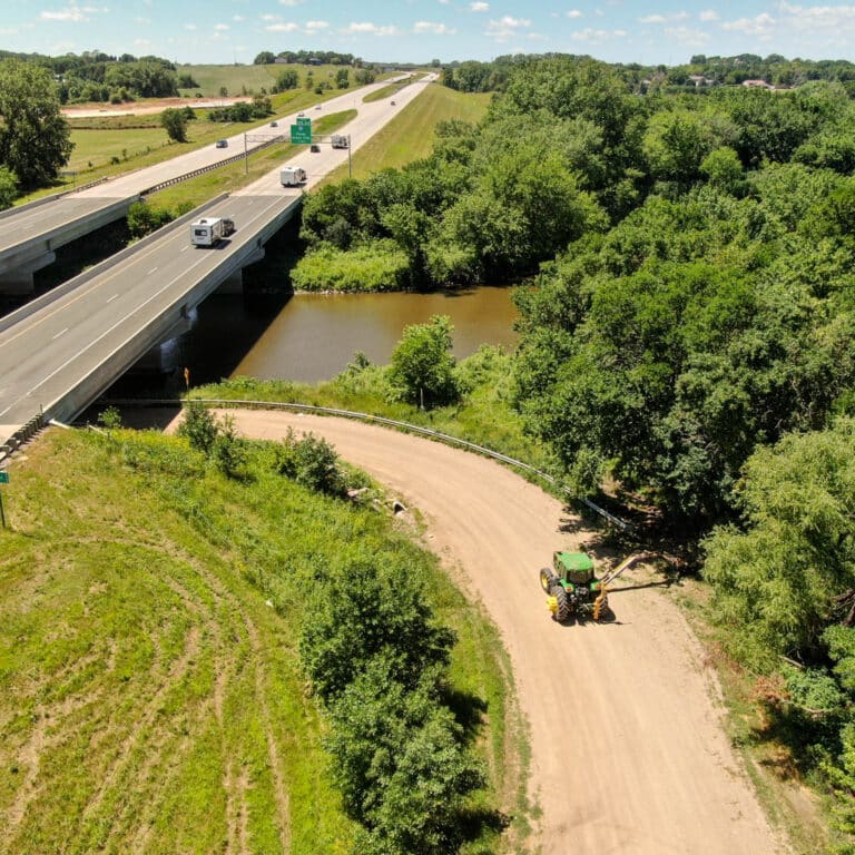 tractor diamond boom drum driving by a river