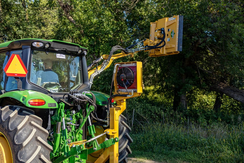 tractor with boom rotary cutting a tree