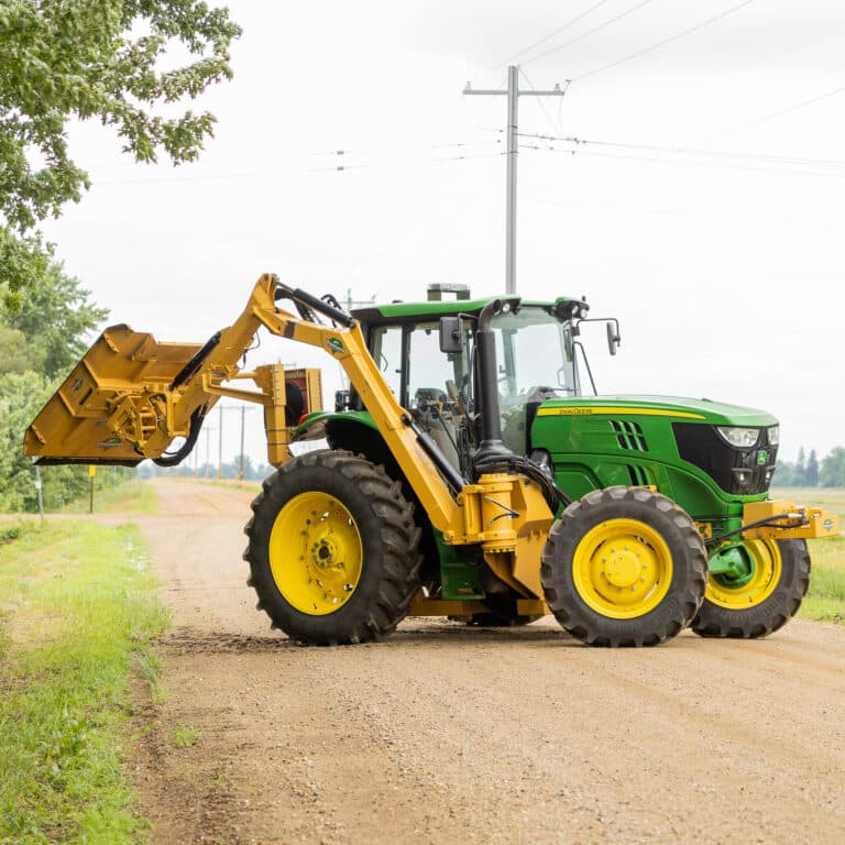 tractor with boom attachment in the road
