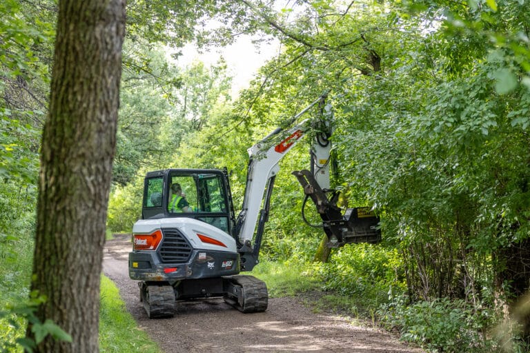 Person inside excavator in the forest.