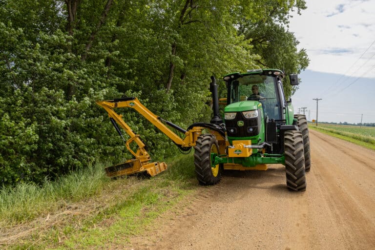 Guy in tractor with boom rotary.